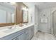 Double vanity bathroom with gray cabinets and a walk-in shower at 5825 Humanity Ln, Raleigh, NC 27616