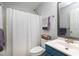 Bathroom featuring white shower curtain, blue vanity, mirror, and purple towels at 109 Stoneline Ct, Holly Springs, NC 27540