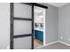 Bedroom view to a bathroom with a blue vanity, decorative mirror, and stylish design through barn door at 109 Stoneline Ct, Holly Springs, NC 27540