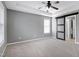 Bright bedroom boasts a tray ceiling, ceiling fan, barn door leading to bathroom, and neutral colors at 109 Stoneline Ct, Holly Springs, NC 27540