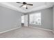 Well-lit bedroom features a tray ceiling, ceiling fan, and a large window providing ample natural light at 109 Stoneline Ct, Holly Springs, NC 27540