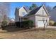 Two-story house with beige siding, attached garage, and landscaping at 109 Stoneline Ct, Holly Springs, NC 27540