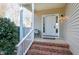 Inviting front porch with brick steps and white railing at 109 Stoneline Ct, Holly Springs, NC 27540