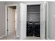 Laundry area featuring modern black washer and dryer and wire shelving in a closet with bi-fold doors at 109 Stoneline Ct, Holly Springs, NC 27540