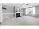 Inviting living room boasts a fireplace, ceiling fan, and a bright window with decorative curtains at 109 Stoneline Ct, Holly Springs, NC 27540