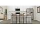 Modern kitchen with white cabinets, stainless steel appliances, and an island with seating at 1848 Poe Farm Ave, Apex, NC 27502
