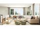 Bright living room featuring a sectional sofa, coffee table, and large windows at 1888 Sweet Gardenia Way, Apex, NC 27502