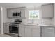 Updated kitchen featuring gray cabinets, granite countertops, and stainless steel appliances at 262 Homestead Dr, Selma, NC 27576