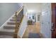 Bright entryway with stairs leading upstairs and views into the kitchen and dining room at 2786 Farmhouse Dr, Apex, NC 27502