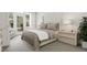 Comfortable bedroom with tufted headboard, neutral tones, and natural light from backyard access at 4077 Elk Creek Ln, Raleigh, NC 27612