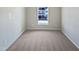 Simple bedroom with grey carpet and window at 5211 Blue Lagoon Ln, Raleigh, NC 27610