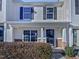 Beige two-story townhome with a covered porch and landscaping at 5211 Blue Lagoon Ln, Raleigh, NC 27610