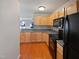 Kitchen with light wood cabinets, dark countertops, and black appliances at 5211 Blue Lagoon Ln, Raleigh, NC 27610