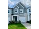 Two-story townhome with gray siding, white garage door, and landscaping at 554 Eversden Dr, Zebulon, NC 27597
