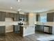 Modern kitchen with gray cabinets, granite island, and stainless steel appliances at 554 Eversden Dr, Zebulon, NC 27597