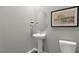 Small powder room with pedestal sink and oval mirror at 70 Saddle Mare St, Clayton, NC 27520