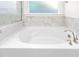 Bathroom with soaking tub and marble tile surround at 1039 Brockton Dr, Mebane, NC 27302