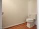 Clean half bath featuring a toilet and hardwood flooring at 121 Lumina Pl, Holly Springs, NC 27540