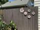 Wooden fence decorated with metal floral art, complemented by a bird feeder and surrounding greenery in a backyard setting at 121 Lumina Pl, Holly Springs, NC 27540