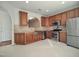 Kitchen features stainless steel appliances, granite counters, wooden cabinets, and open view to other spaces at 121 Lumina Pl, Holly Springs, NC 27540