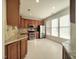 Well-lit kitchen with stainless appliances, wooden cabinets, granite countertops, and bright white painted flooring at 121 Lumina Pl, Holly Springs, NC 27540