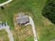 An aerial view shows a home with a gray roof, surrounded by greenery and a gravel driveway at 1820 Johnson Rd, Burlington, NC 27217
