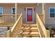 Inviting entrance with a red door framed by wood stairs and black house numbers at 1820 Johnson Rd, Burlington, NC 27217