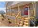 Inviting front porch with natural wood stairs and a bright red front door at 1820 Johnson Rd, Burlington, NC 27217