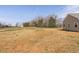 Lush backyard with a glimpse of the home's exterior and the surrounding landscape at 1820 Johnson Rd, Burlington, NC 27217