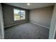 Well-lit bedroom featuring a large window and carpet at 228 Mahogany Way, Four Oaks, NC 27524