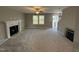 Living room with gray walls, a fireplace, and a view of the kitchen at 228 Mahogany Way, Four Oaks, NC 27524
