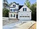 New construction two-story home featuring white siding, black shutters, and a two-car garage with a paved driveway at 2628 Silver Gate Ct, Wake Forest, NC 27587