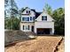 New construction home with white siding, black shutters, and an unfinished driveway at 2628 Silver Gate Ct, Wake Forest, NC 27587