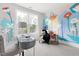 Bright bedroom with a large window, whimsical floral art, a grey desk, and a comfortable accent chair at 296 Two Creeks Lp, Chapel Hill, NC 27517