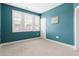 Blue bedroom featuring a window with white shutters, plush carpeting, and crisp white trim at 296 Two Creeks Lp, Chapel Hill, NC 27517