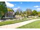 Scenic pond with a rock waterfall, lush landscaping, and a sidewalk for enjoying the view at 296 Two Creeks Lp, Chapel Hill, NC 27517