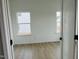 Bright bedroom with two windows, hardwood floors, and neutral colors at 4327 Emeline Way # 10, Fuquay Varina, NC 27526