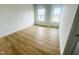 A modern bedroom with wood-look flooring and two large windows that bring in natural light at 4327 Emeline Way # 10, Fuquay Varina, NC 27526