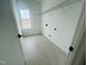 New laundry room with gray hexagonal tile floors and white walls with washer and dryer hookups at 4327 Emeline Way # 10, Fuquay Varina, NC 27526