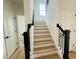 Modern staircase with wooden steps and black banister, leading to the upper level at 4327 Emeline Way # 10, Fuquay Varina, NC 27526