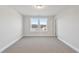 Bedroom with neutral walls and carpeting features a large window with neighborhood views at 545 Eversden Dr, Zebulon, NC 27597