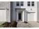 Close up of a new construction home's front entrance with dark door and attached one car garage at 545 Eversden Dr, Zebulon, NC 27597