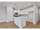 Bright kitchen features white cabinets, stainless steel appliances, kitchen island with sink, and wood floors at 545 Eversden Dr, Zebulon, NC 27597