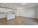 Open-concept kitchen and living room with wood flooring, recessed lighting, and lots of natural light at 545 Eversden Dr, Zebulon, NC 27597