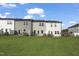 Spacious backyard with green grass and rear view of attached townhome at 556 Eversden Dr, Zebulon, NC 27597