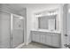 Spacious bathroom with a double vanity, large mirror, and a glass-enclosed shower with modern fixtures at 556 Eversden Dr, Zebulon, NC 27597