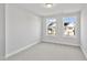 Bright bedroom featuring neutral carpet, base molding, and windows with neighborhood views at 556 Eversden Dr, Zebulon, NC 27597