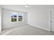 Bright bedroom with neutral carpet, white walls, and two windows offering a view of the neighborhood at 556 Eversden Dr, Zebulon, NC 27597