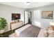 Virtually staged bedroom with wood-look floors, dresser, and large TV at 708 N Allen Rd, Wake Forest, NC 27587
