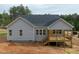 View of the back of the home with gray siding and a wooden deck with black railings at 95 Purslane Dr, Franklinton, NC 27525